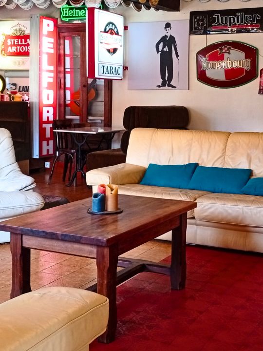 L'Estaminet — Le salon<br />Devant la cheminée, un espace salon convivial pour s'installer, discuter, prendre un verre ou simplement prolonger la soirée. L'Estaminet — Le salon<br />Devant la cheminée, un espace salon convivial pour s'installer, discuter, prendre un verre ou simplement prolonger la soirée.